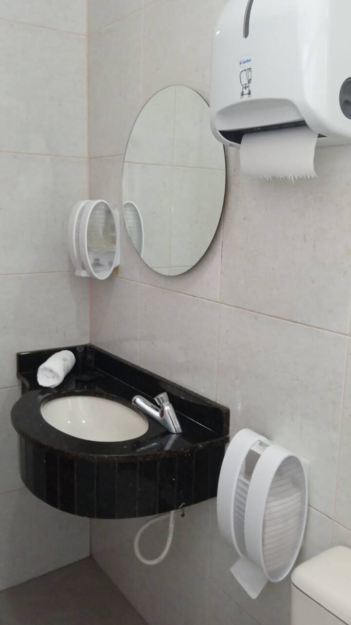 Banheiro com pia de granito e espelho oval