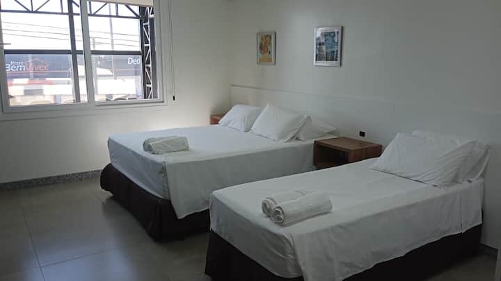 Quarto com duas camas de solteiro e janela ampla