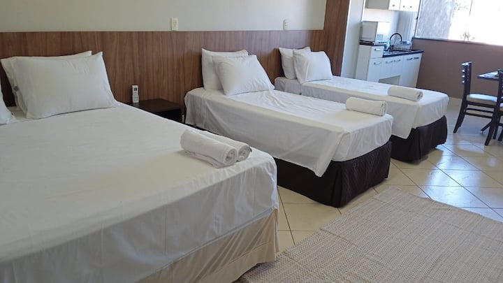 Quarto amplo com múltiplas camas e ambiente espaçoso