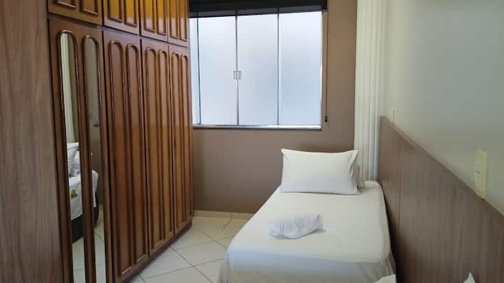 Quarto individual com guarda-roupa de madeira ripada