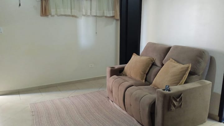 Sala de estar com sofá bege e tapete listrado